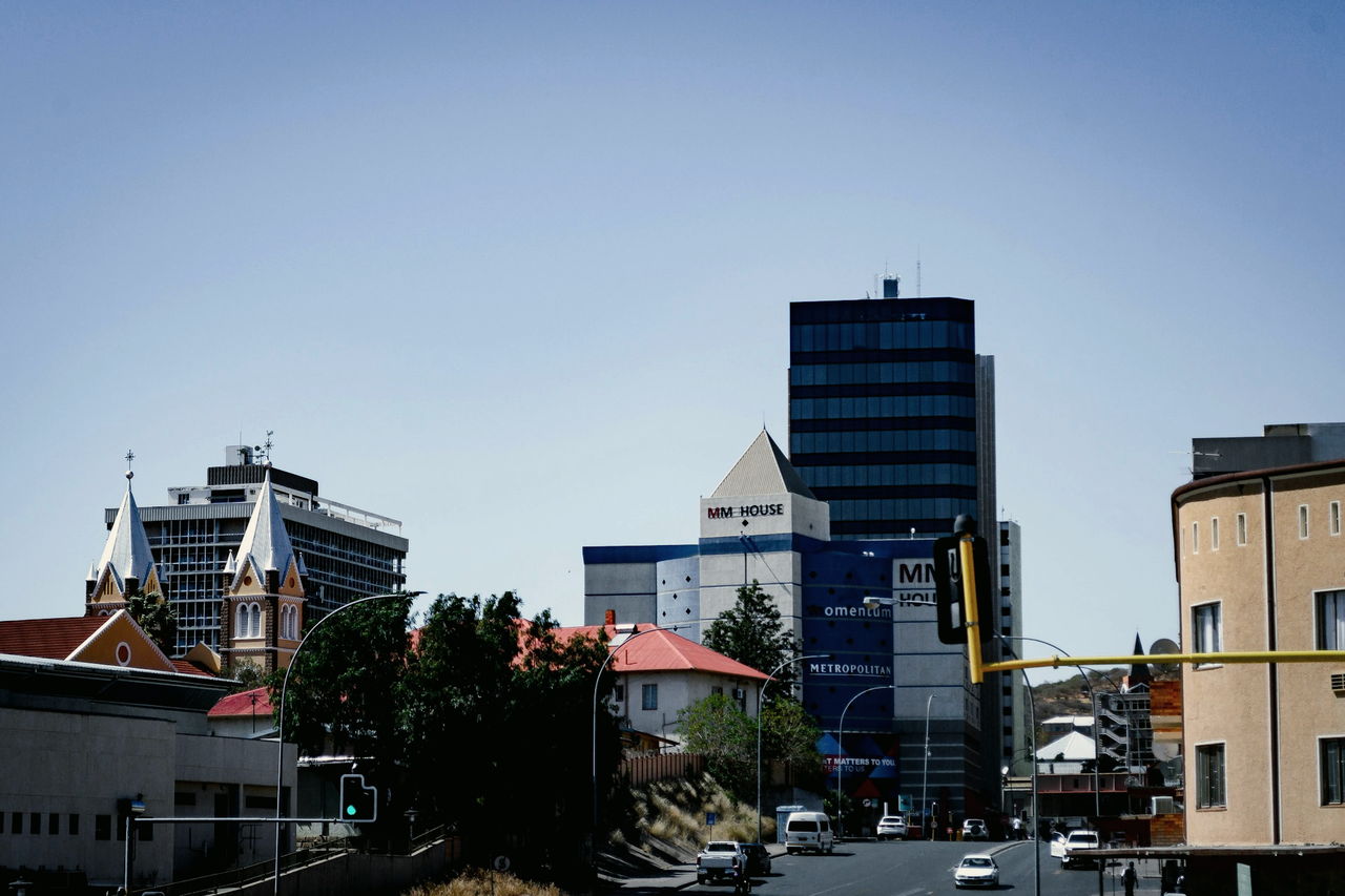 A street in Windhoek with traffic passing tall buildings